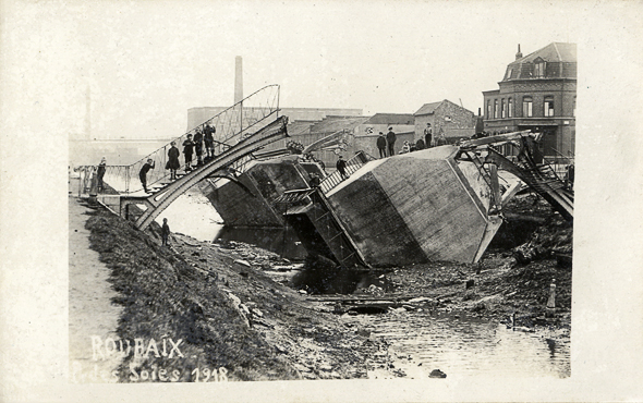 <b><i>Passerelle des soies détruite en 1918.</b></i><br/>Carte postale noir et blanc (Médiathèque municipale de Roubaix)